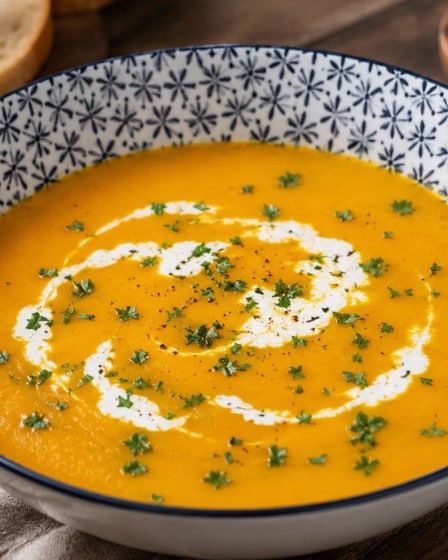 Kürbiscremesuppe mit einem Schuss Sahne in einem Suppenteller