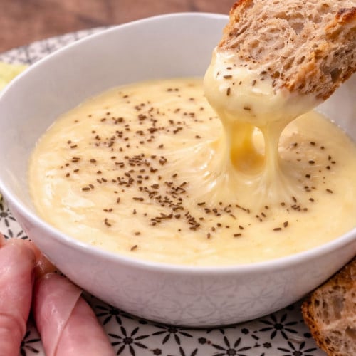 Kochkäse mit Brot in einem Schälchen mit Kochschinken, Brot und Salatgurke