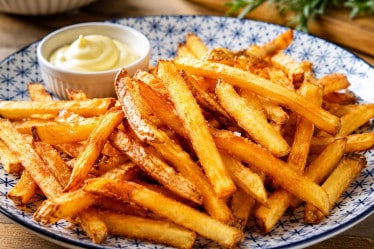 Selbstgemachte Pommes auf einem Teller mit Mayo