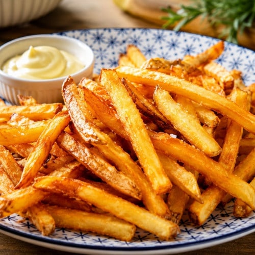 Selbstgemachte Pommes auf einem Teller mit Mayo