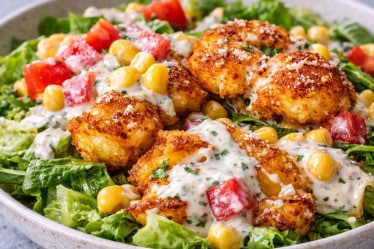 Smashed-Potatoe-Salat mit Dressing auf einem Teller