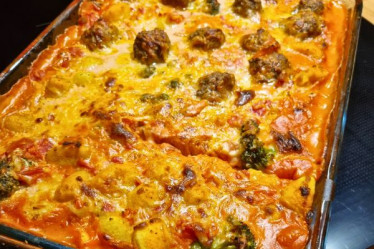 Das Bild zeigt einen Gnocchi-Auflauf mit Hackbällchen und Brokkoli in Tomatensoße