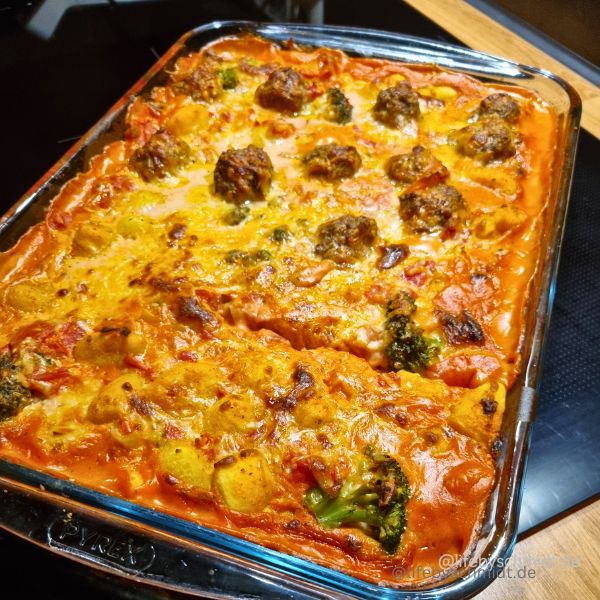 Das Bild zeigt einen Gnocchi-Auflauf mit Hackbällchen und Brokkoli in Tomatensoße