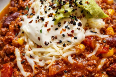 Klassisches Chili con Carne mit Sour Cream, Avocado und geriebenem Käse