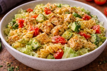 Pastasalat mit Hähnchen, Paprika, Eisbergsalat, Käse, Avocado und cremigem Dressing