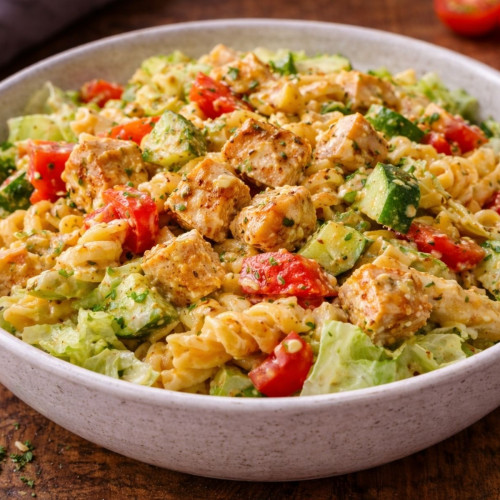 Pastasalat mit Hähnchen, Paprika, Eisbergsalat, Käse, Avocado und cremigem Dressing
