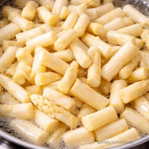Weißer Spargel in Stücke geschnitten beim Kochen im Topf